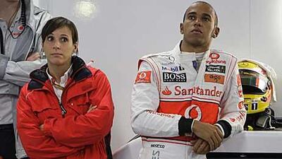 Lewis Hamilton, right, waits in the pit garage for the qualifying session to begin for the Japanese Grand Prix at the Suzuka Circuit.