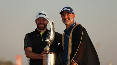 Paul Waring of England, right, poses with his caddie, Alex Evans and the trophy on the 18th green. Getty Images