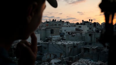 In this September 12, 2018, photo, a boy looks out of the window as the sun sets in Gaza City. AP