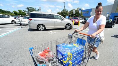 Sheila Guerra wheels groceries to her car at a Wal-Mart Super Store in Orlando. AFP