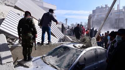 A soldiers stands on a damaged car in the aftermath of an Israeli strike on the Syrian capital, Damascus, on January 20. EPA