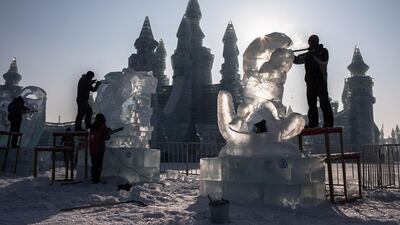 Participants carve their ice sculptures. EPA