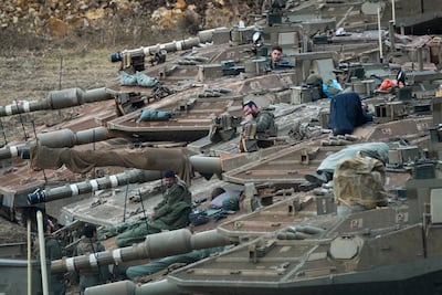Israeli soldiers work on tanks in a staging area in northern Israel near the Israel-Lebanon border. AP