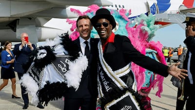 French President Emmanuel Macron is welcomed by members of the Crescent City All Star Band upon arrival at Louis Armstrong New Orleans International Airport in Kenner, Louisiana on December 2, 2022. (Photo by Ludovic MARIN / POOL / AFP)