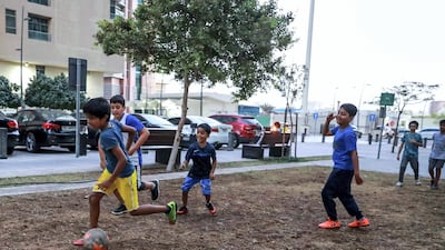 Children who live in the neighbourhood meet to play football on the grassy square outside Jones the Grocer in Khalidiya. Victor Besa / The National