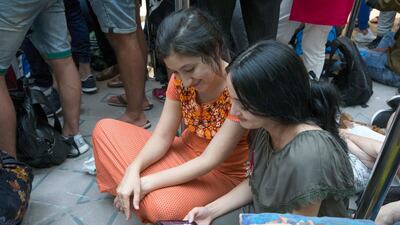 Apple customers queue through the night to be one of the first to get the new Apple devices. Leslie Pableo / The National