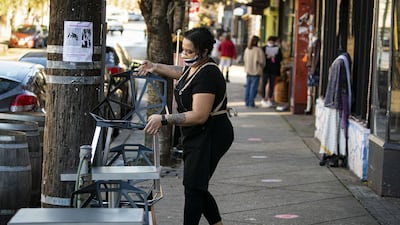 A worker wearing a protective mask sets up outdoor seating at a restaurant in the Hampden neighborhood in Baltimore, Maryland. Bloomberg