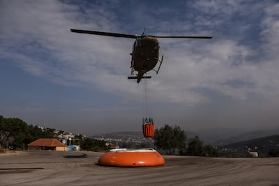 A helicopter picks up water, to douse areas fire trucks cannot reach, at the Deir Al Kalaa monastery near the town of Beit Mery on November 15. Elizabeth Fitt