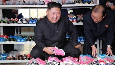 In contrast to the harsh rhetoric of the statement, Mr Kim was seen smiling during the shoe factory visit. Picture via KCNA.