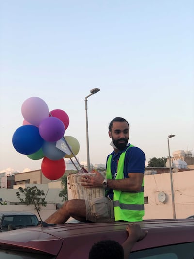 A Live to Give volunteer distributes Eid gifts. Mariam Nihal / The National
