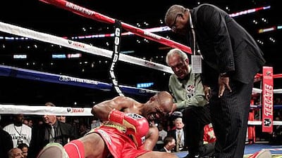 Bernard Hopkins grimaces as he clutches his left shoulder after being dumped on the canvass by his WBC light heavyweight challenger Chad Dawson. Hopkins was adjudged to lost by TKO.