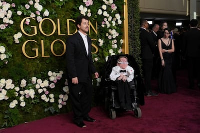 Ramy Youssef, left, and Steve Way arrive at the 82nd Golden Globes, with the latter wearing a ceasefire pin. AP