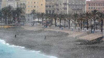 People walk through heavy snowfall along the Promenade des Anglais on February 26, 2018 in Nice. Valery Hache / AFP