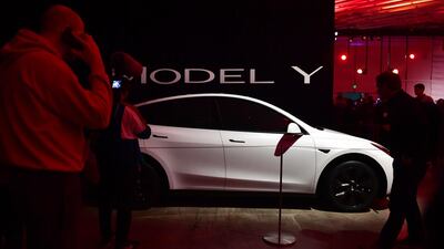 People view a model of the new Tesla Model Y. AFP