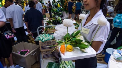 A Thai woman holds a tray with carved fruit and vegetable decorations during a fruit and vegetable carving competition in Bangkok. Robert Schmidt / AFP