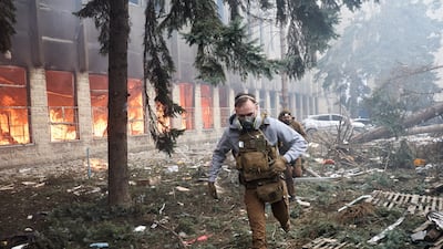 Ukrainian troops run near the site of a rocket attack on an industrial building, in Kharkiv. EPA