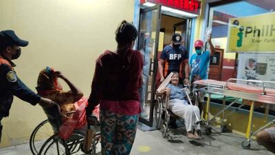 Bureau of Fire Protection staff moving patients from the hospital after the earthquake. Reuters