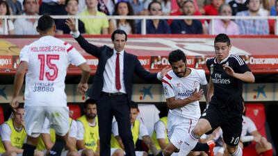 Sevilla players challenge Real Madrid’s James Rodriguez, right, as coach Unai Emery looks on. Marcelo del Pozo / Reuters
