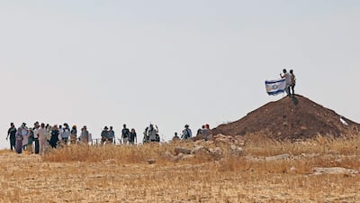 Israeli settlers carry a flag as Palestinian and Israeli activists accompany Palestinian landowners to their property in Beit Sahur, south of Bethlehem, in the occupied West Bank last week. AFP