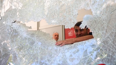 Cleaning and security contractors examine a damaged window of a Caisse d'Epargne bank in the centre of Marseille in France. AP