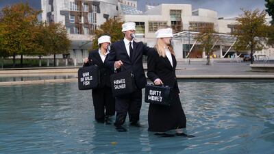 On Friday suited performers from Ocean Rebellion protest at Holyrood Pond, outside the Scottish Parliament in Edinburgh, calling on Scottish Government to wind down the environmental tragedy of salmon farming with a just transition for workers. PA