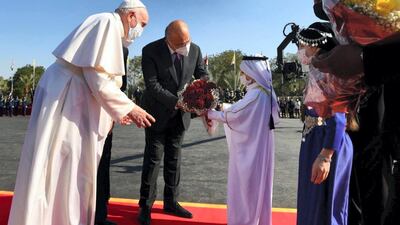 Pope Francis receives a gift as he arrives at Iraq's Presidential Palace. Office of the President
