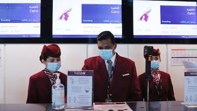 Qatar Airways employees wait at the boarding counter ahead of the first flight bound for Cairo after the resumption of flights between Qatar and Egypt, at Qatar's Hamad International Airport on January 18, 2021. AFP