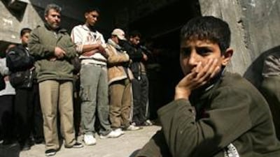 A Palestinian boy waits while mourners pray over the body of six-year-old Mlak Abu Eita and three other members of her family. They were killed in an Israeli missile strike in Beit Lahiya just hours before an Israeli ceasefire was announced.