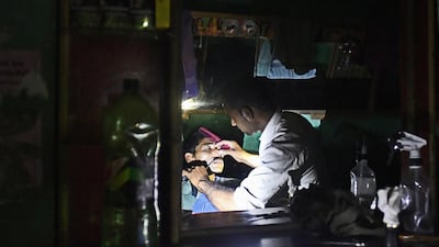 A customer gets a shave at a barber shop illuminated by the torch function of a mobile phone at night in a village on the outskirts of Alwar, Rajasthan, India. A new report says despite improvements, 1 billion people still live without electricity. Anindito Mukherjee/Bloomberg