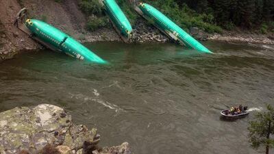 Brock Sarbeck provided by Wiley E. Waters Whitewater Rafting shows a freight train that derailed near Alberton in western Montana, sending three cars carrying aircraft components down a steep embankment and into the Clark Fork River on Thursday. Brock Sarbeck / AP