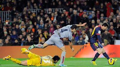 Barcelona's Lionel Messi rounds Osasuna's Miguel Flano and goalkeeper Andres Fernandez on route to goal.