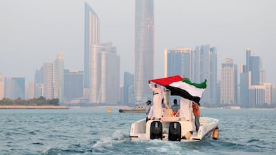 The UAE flag is held up on a boat in Abu Dhabi. Today, the nation-states that have succeeded are those that have redefined security from within. Chris Whiteoak / The National