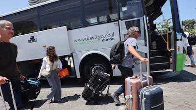 Israelis disembark from a coach after being flown back to Tel Aviv on repatriation flights. AFP