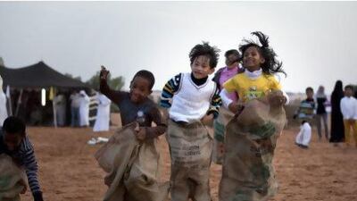 Children sack jumping in the desert near Al Ain at the Dar Zayed for Family Car's Family Day. Silvia Razgova / The National