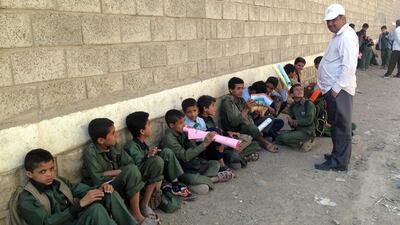Yemeni children sit outside their school on Monday in the disctrict of Chamlane in northern Sanaa. The students were not able to enter their school as it has been used to store weapons by Houthi Shiite rebels. Gamal Noman / AFP