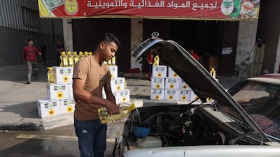A Palestinian man funnels cooking oil into the engine of his car in Rafah in the southern Gaza Strip. AFP