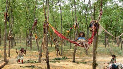 Children of Indian labourers play on make-shift swings in Amritsar. Narinder Nanu / AFP