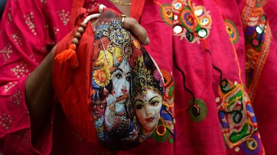 A devotee holds a bag containing prayer beads for the occasion. AFP