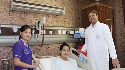 Palestinian Ghadeer Al Titi, 18, who was severely burnt as a child, recovers after undergoing free plastic surgery at the hands of Dr Matteo Vigo, right, at The American Academy of Cosmetic Surgery Hospital in Dubai. Courtesy The American Academy of Cosmetic Surgery Hospital