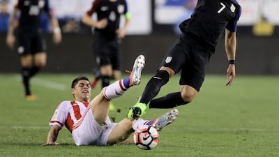 Bobby Wood, right, of United States is tripped by Miguel Samudio of Paraguay. Elsa / Getty Images