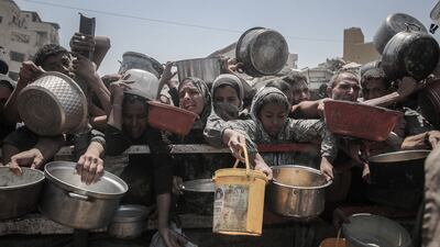 Palestinians gather to receive food from a charity distribution point in Gaza city. Bloomberg