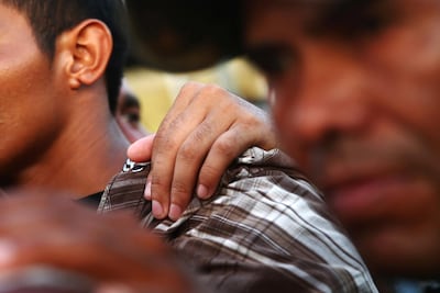 A Central American migrant, part of a caravan trying to reach the US, puts his hand on the shoulder of another migrant, in Ciudad Hidalgo, Mexico October 22, 2018. Reuters