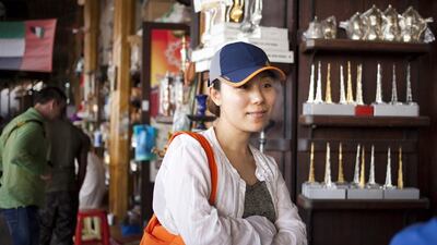 A Chinese tourist shops for spices at the Spice Souk in Deira. Razan Alzayani / The National