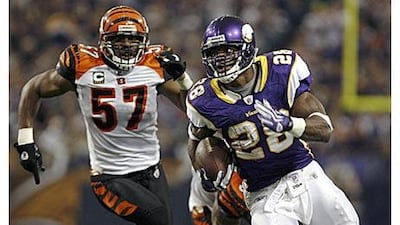 The Minnesota Vikings running back Adrian Peterson, right, rushes for a gain and first down past Cincinnati Bengals linebacker Dhani Jones in the second quarter.