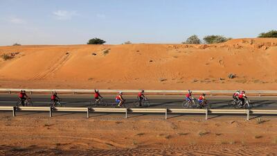 Fourteen employees of RAKBank wore matching red shirts when they cycled to their office, bringing admiring looks from passing motorists. Before their 17-kilometre journey they all met up to check their bikes. Pawan Singh / The National