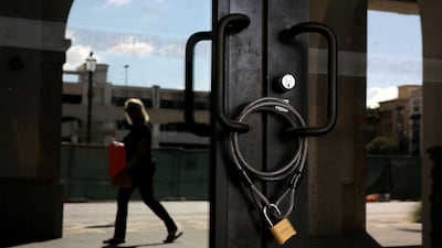 A restaurant is seen closed as a woman walks past at an empty commercial area after local authorities restricted the activities of restaurants, bars, gyms, movie theaters and other similar businesses in West Palm Beach, Florida, US. Reuters