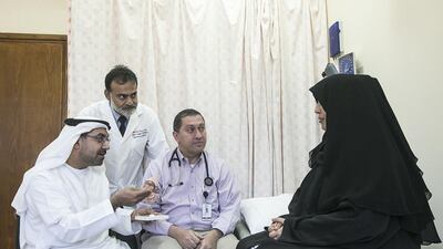 From left, Dr Ali Obaidli, chair of the National Transplant Committee, Dr Muhammad Zaman, head of transplantation services at Seha’s Sheikh Khalifa Medical City and Dr Nizar Attallah, consultant nephrologist, Cleveland Clinic Abu Dhabi with Fatima Al Blooshi. Mona Al Marzooqi / The National