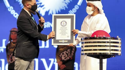 A Guinness World Record official presented Bader Anwahi, chief executive of Global Village, with the 25th certificate of the season. Chris Whiteoak / The National
