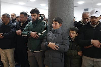 Relatives pray during the funeral of four members of the Bani Odeh family. EPA