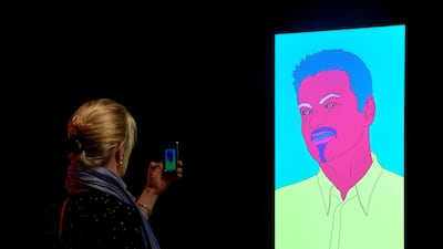 A visitor photographs 'Commissioned Portrait Untitled (George)' by Michael Craig-Martin ahead of the George Michael online auction at Christie's. Reuters